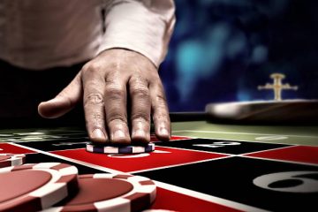 hand betting on roulette number at casino table
