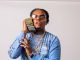 Rapper Gunna Flashy Fit With Money to his ear